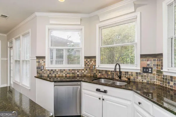 a kitchen with granite countertop a sink and a window