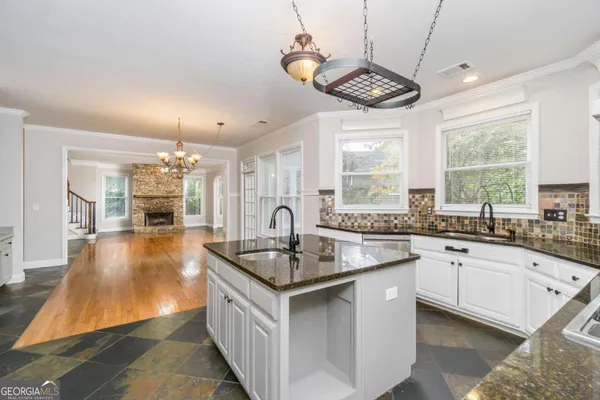 a kitchen with granite countertop a sink stove and cabinets
