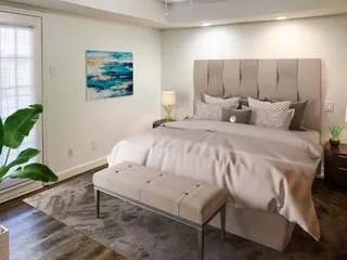 a bedroom with a bed and a potted plant on the table