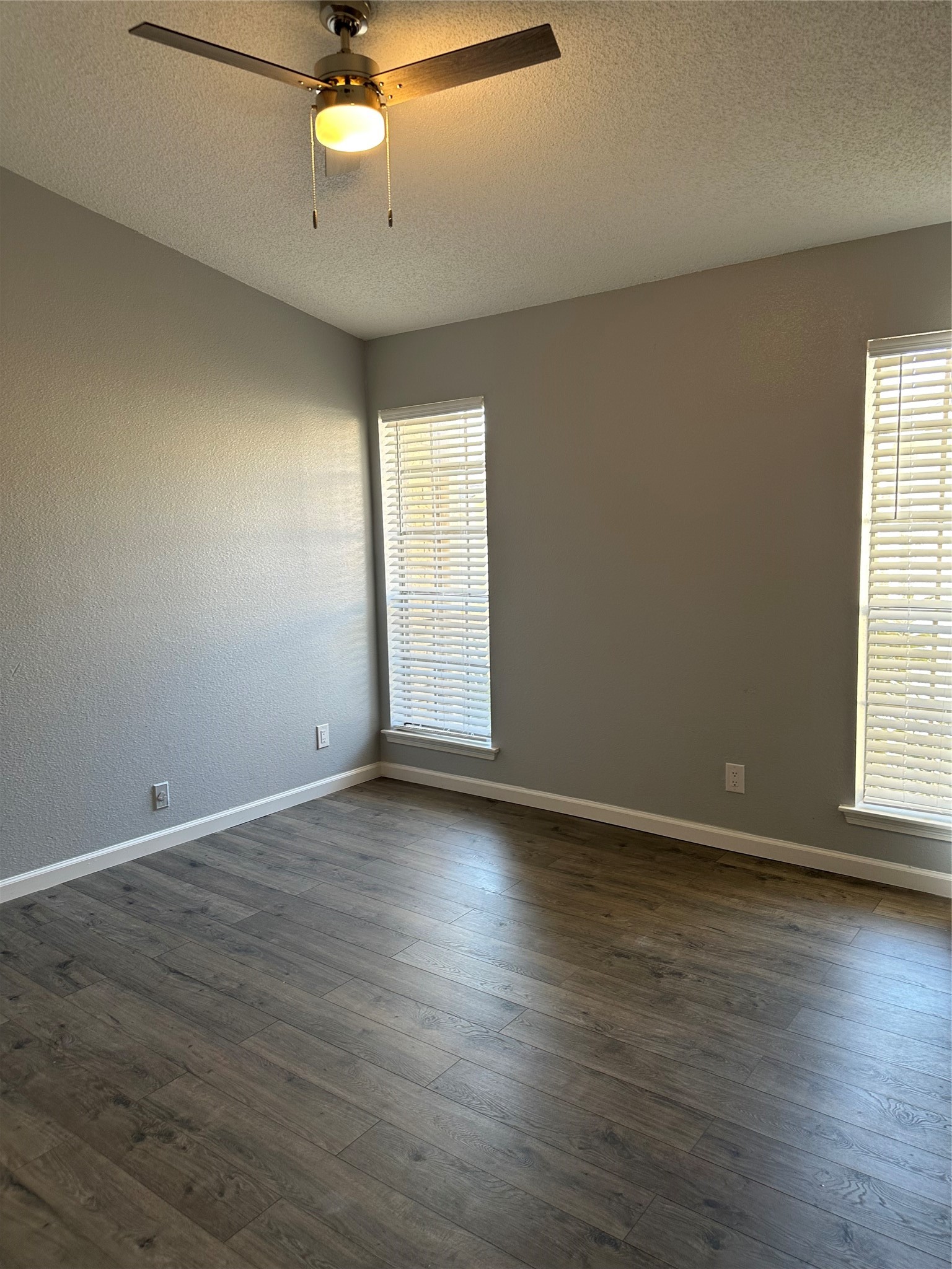 7575 Cambridge Street, Unit 2303 Houston, TX 77054 - Photo 6 of 7 an empty room with wooden floor chandelier fan and windows