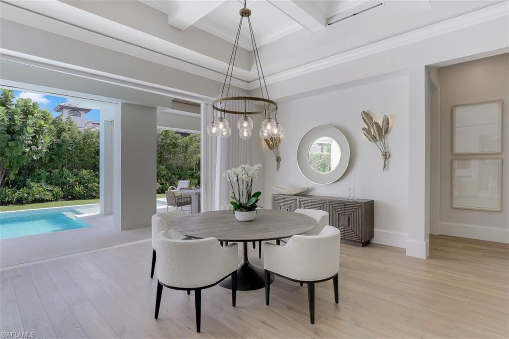 650 Wedge Drive Naples, FL 34103 - Photo 11 of 34 a dining room with furniture a chandelier and a rug