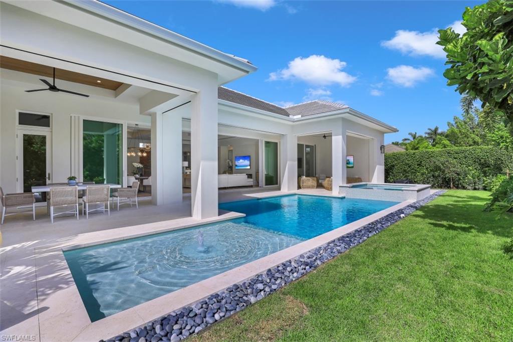 650 Wedge Drive Naples, FL 34103 - Photo 2 of 34 a view of a house with a backyard porch and sitting area