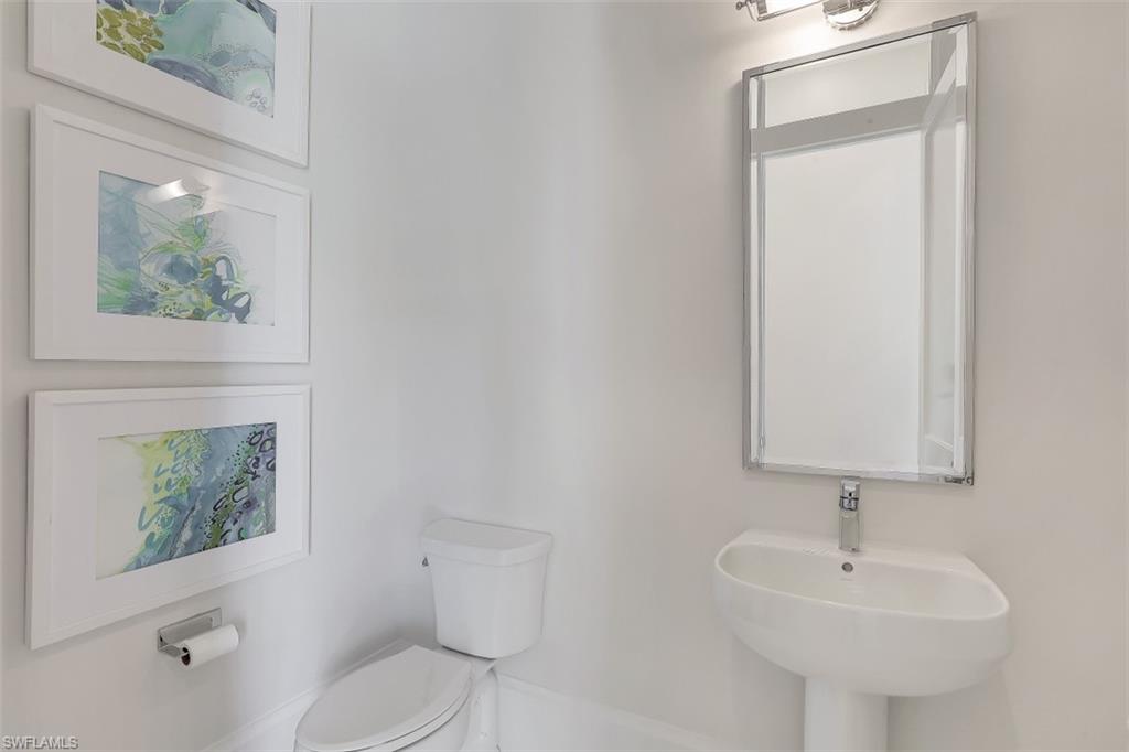 650 Wedge Drive Naples, FL 34103 - Photo 23 of 34 a bathroom with a sink toilet and mirror