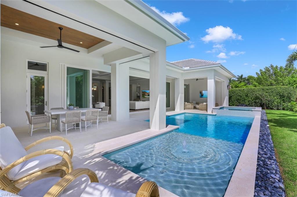 650 Wedge Drive Naples, FL 34103 - Photo 30 of 34 a view of a patio with couches table and chairs with wooden floor and fence
