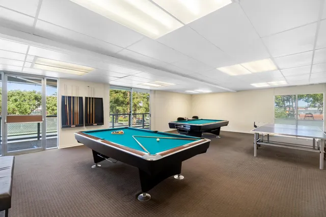 a room with pool table and windows