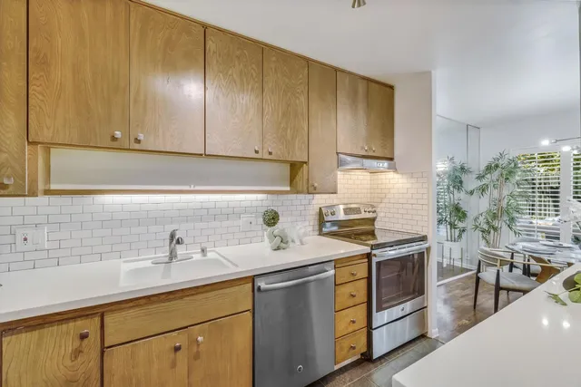 a kitchen with stainless steel appliances granite countertop a sink stove and cabinets