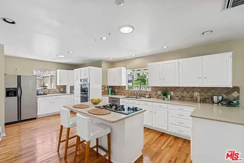 a kitchen with a sink stove and white cabinets