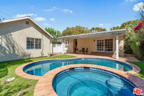 a swimming pool with outdoor seating and yard