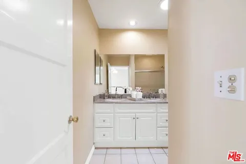 a bathroom with a granite countertop sink a toilet and a mirror