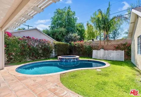 a view of a backyard with plants and patio