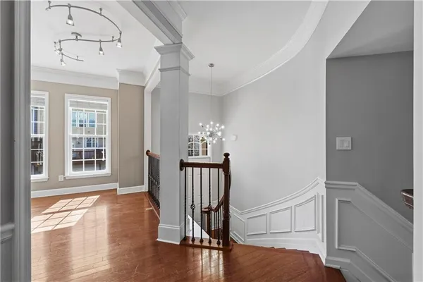 a view of a hallway with wooden floor and dining room view