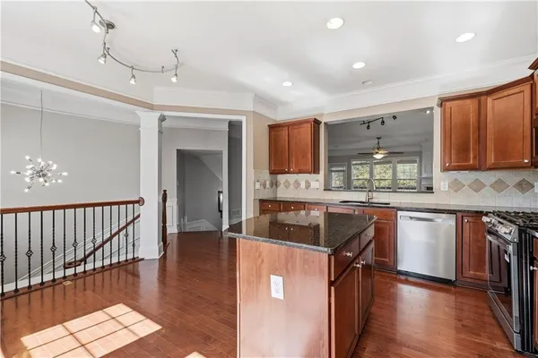 a kitchen with kitchen island granite countertop wooden floors granite counter tops and a window