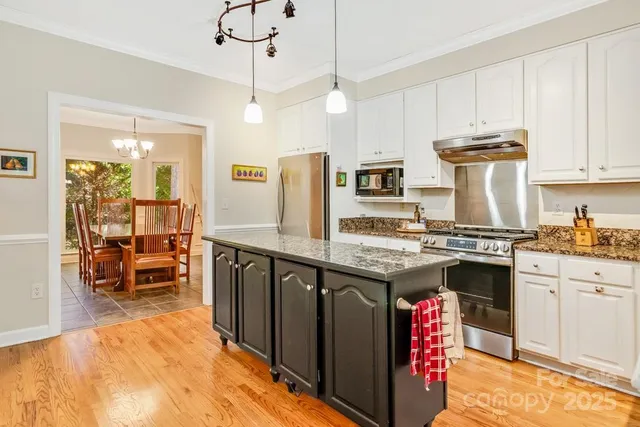 a kitchen with kitchen island granite countertop a stove and a sink