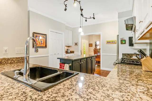 a kitchen with kitchen island granite countertop a sink stove and refrigerator
