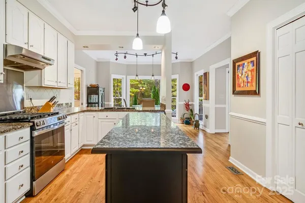 a kitchen with stainless steel appliances granite countertop a stove oven and a refrigerator
