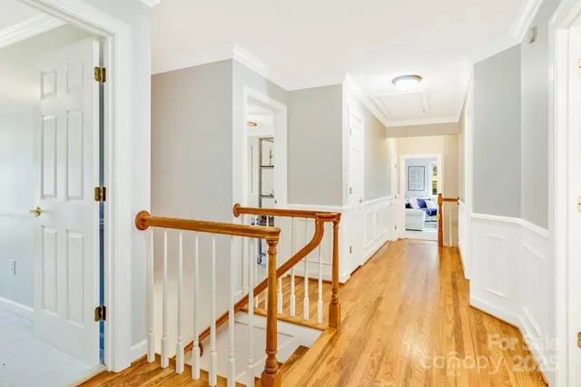 a view of a hallway with wooden floor and staircase
