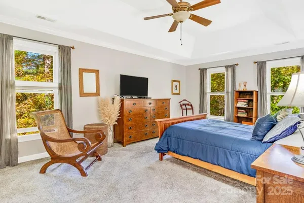 a bedroom with a bed and a flat tv screen on the dresser