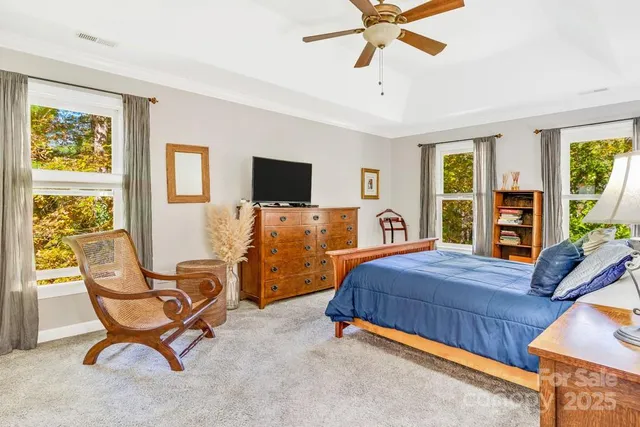 a bedroom with a bed and a flat tv screen on the dresser