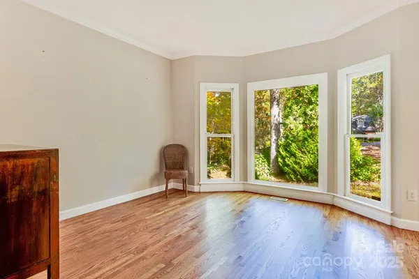 a view of room with a large window and wooden floor
