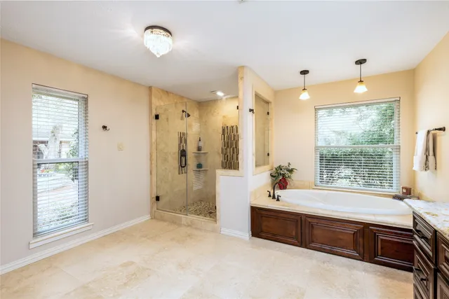 a spacious bathroom with a tub double sink window and mirror