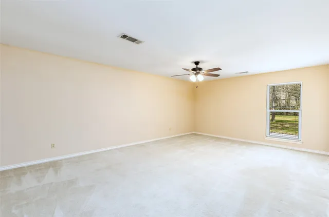 a view of a room with a window and a ceiling fan