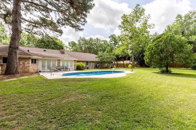an aerial view of residential house with outdoor space and trees all around