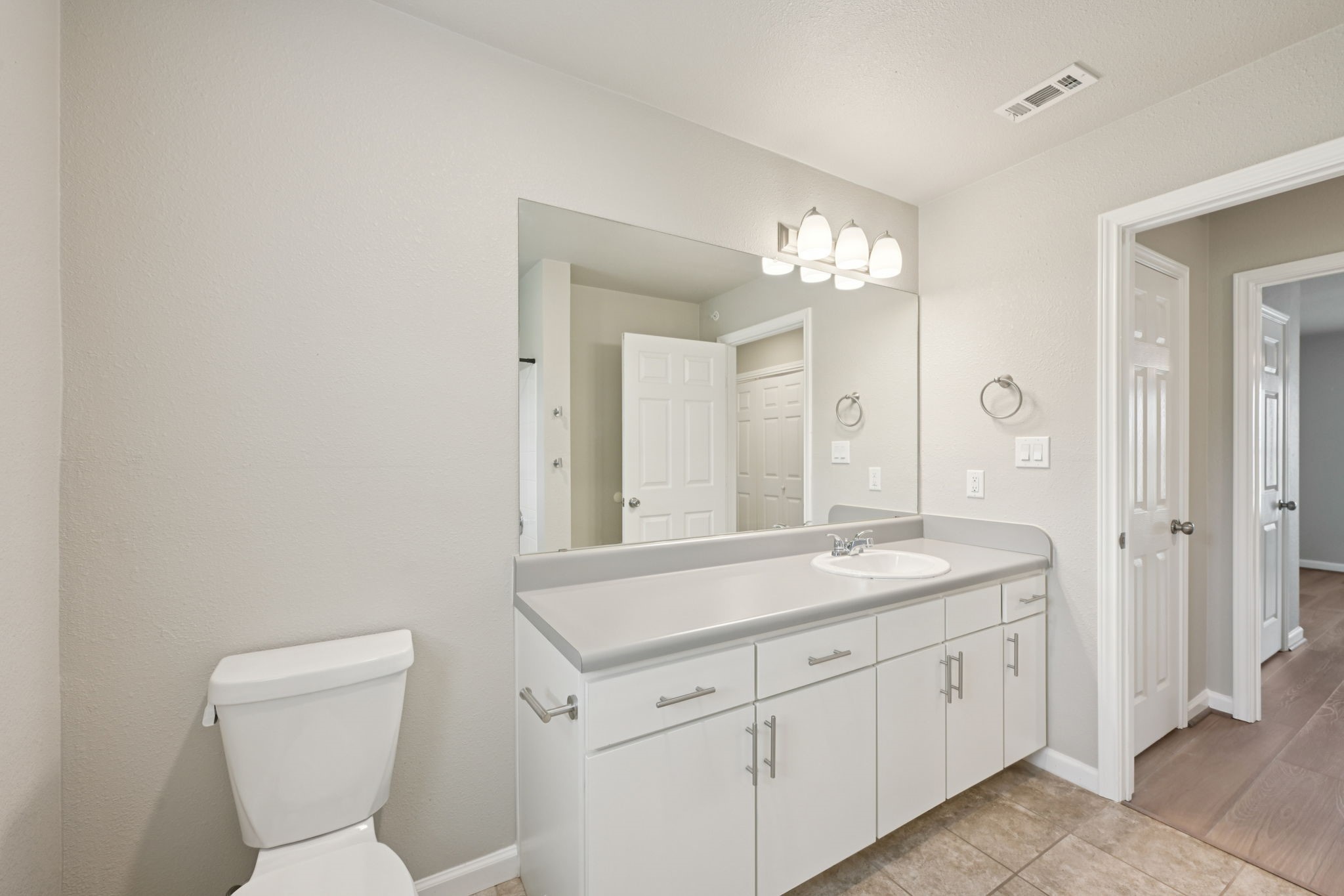 254 Plez Morgan Drive, Unit F Montgomery, TX 77356 - Photo 22 of 31 a spacious bathroom with a toilet a sink and mirror