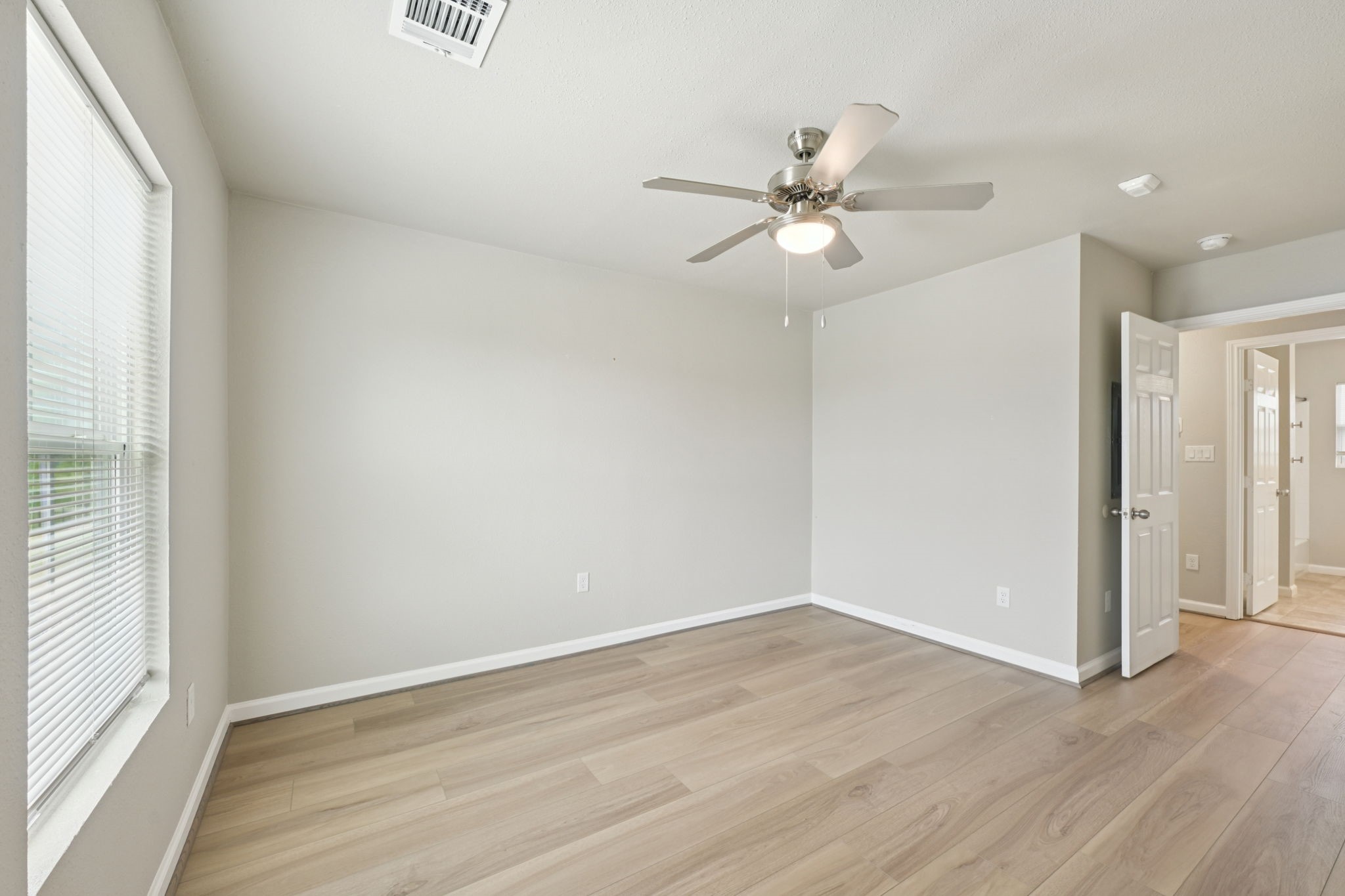 254 Plez Morgan Drive, Unit F Montgomery, TX 77356 - Photo 25 of 31 an empty room with wooden floor fan and windows