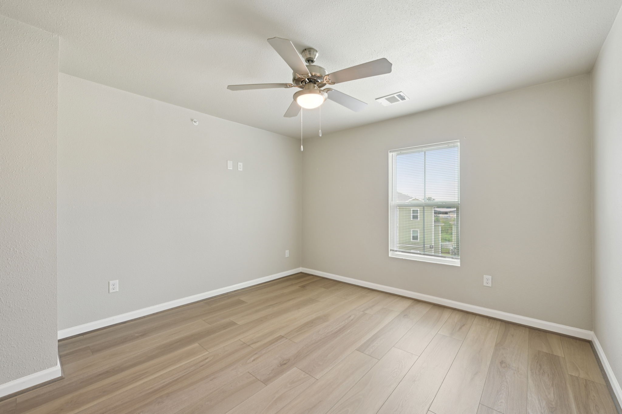 254 Plez Morgan Drive, Unit F Montgomery, TX 77356 - Photo 27 of 31 an empty room with wooden floor fan and windows