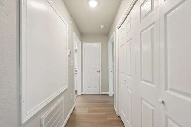 a view of a hallway with wooden floor and entryway