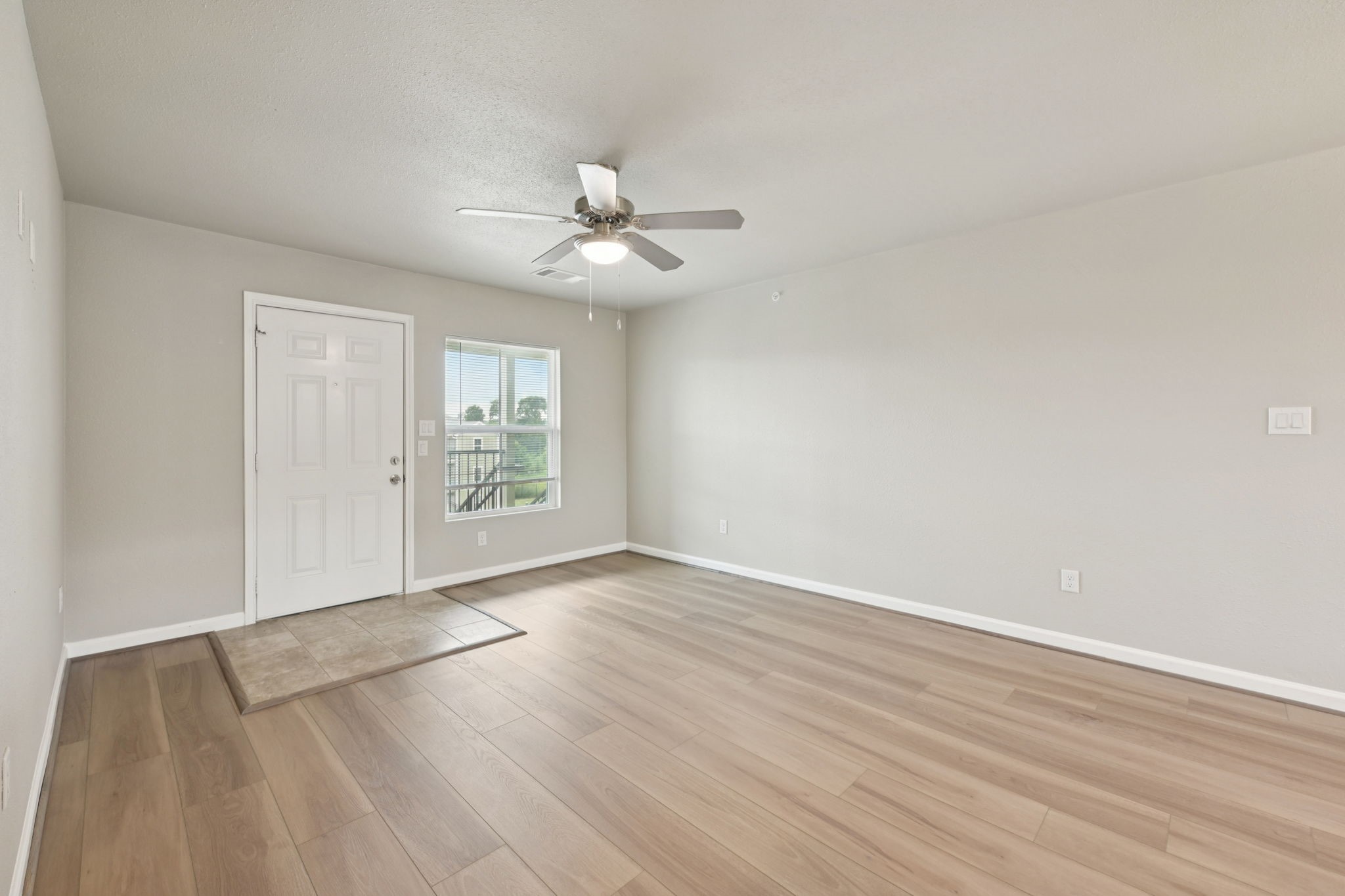 254 Plez Morgan Drive, Unit F Montgomery, TX 77356 - Photo 7 of 31 wooden floor in an empty room with a window