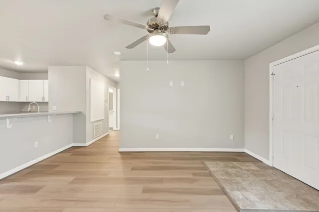a view of an empty room and kitchen view