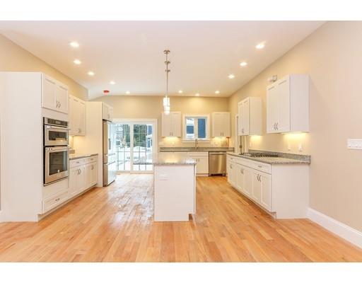 46 Colburn Street Westwood, MA 02090 - Photo 8 of 30 a large white kitchen with kitchen island a sink a stove a refrigerator and white cabinets