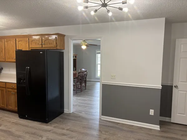 an empty room with wooden floor and a hallway
