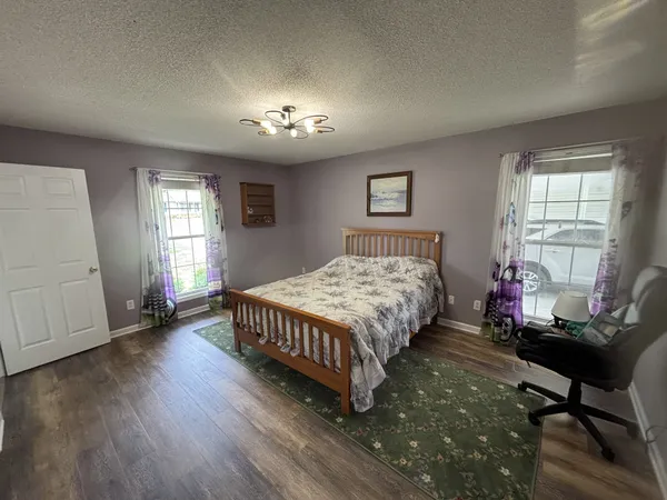 a bedroom with a bed mirror and a window