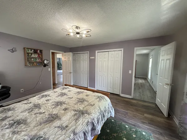 a spacious bedroom with a large bed and a chandelier