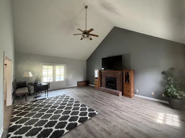 a living room with furniture a fireplace and a flat screen tv