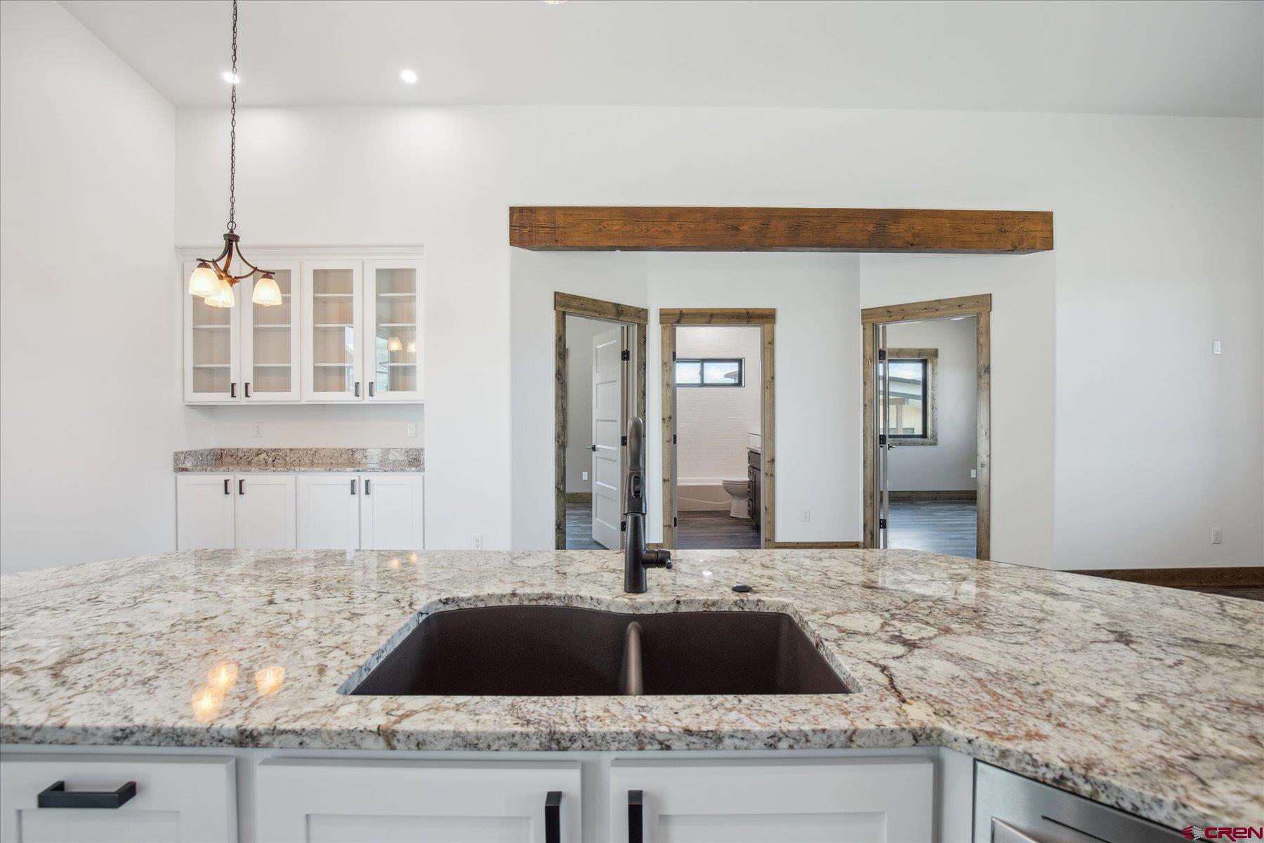 8847 Road 26.7 Cortez, CO 81321 - Photo 19 of 29 a kitchen with granite countertop a sink and a stove