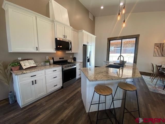 8847 Road 26.7 Cortez, CO 81321 - Photo 7 of 29 a kitchen with stainless steel appliances kitchen island granite countertop a stove a sink and a microwave