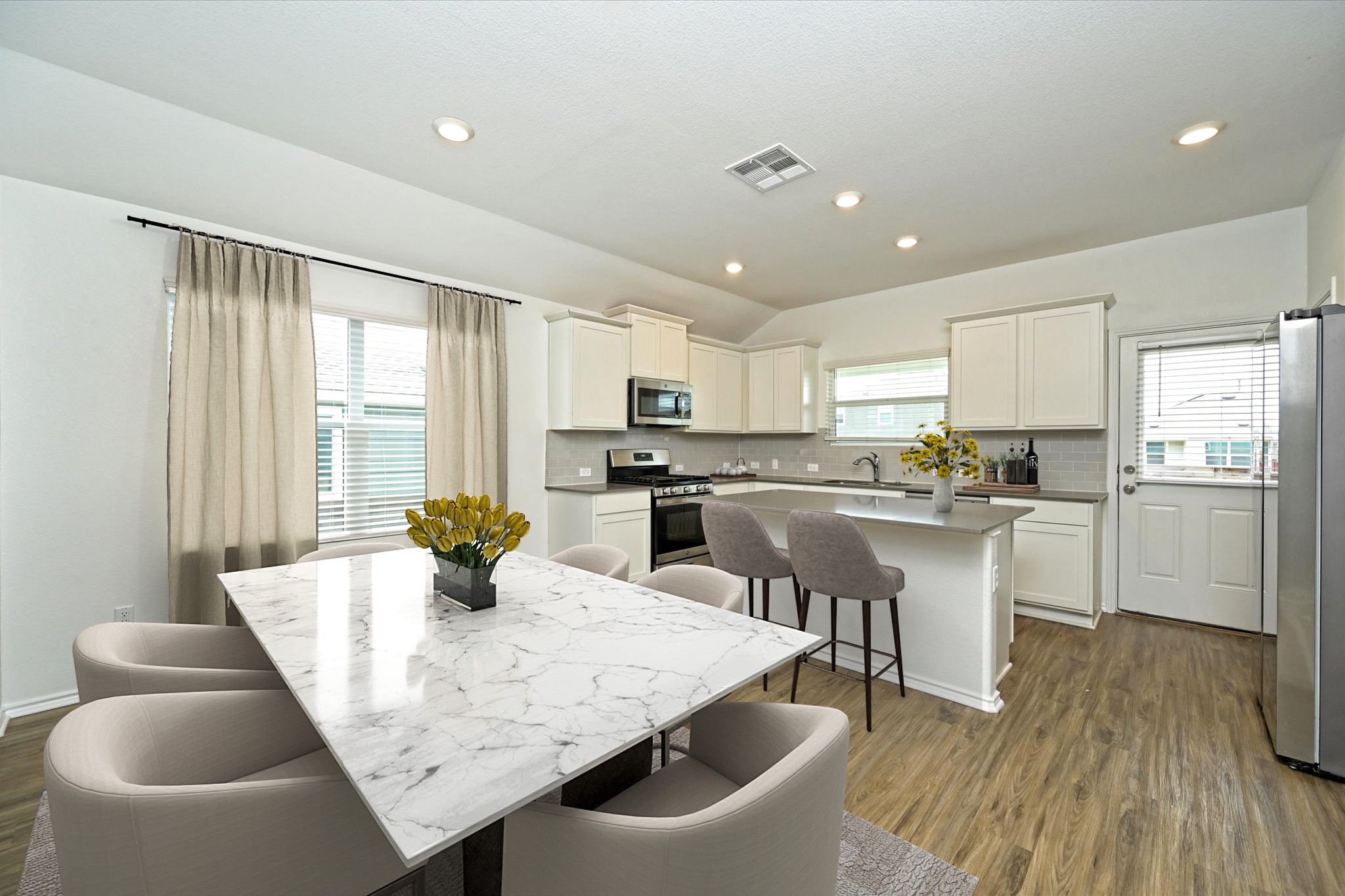 180 Madrid Kyle, TX 78640 - Photo 11 of 32 a kitchen with a table chairs refrigerator and microwave