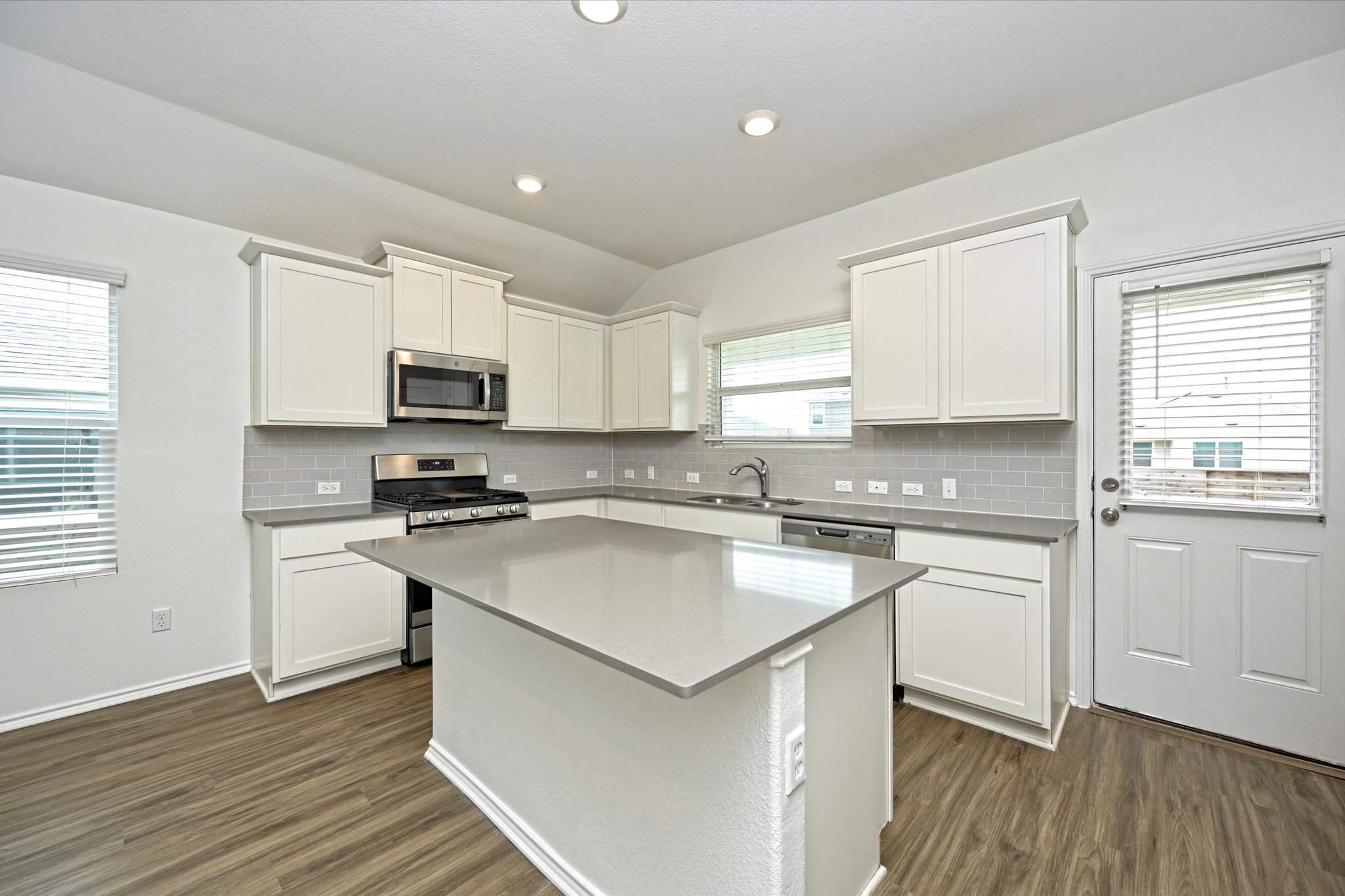 180 Madrid Kyle, TX 78640 - Photo 13 of 32 a kitchen with a sink stove top oven and refrigerator
