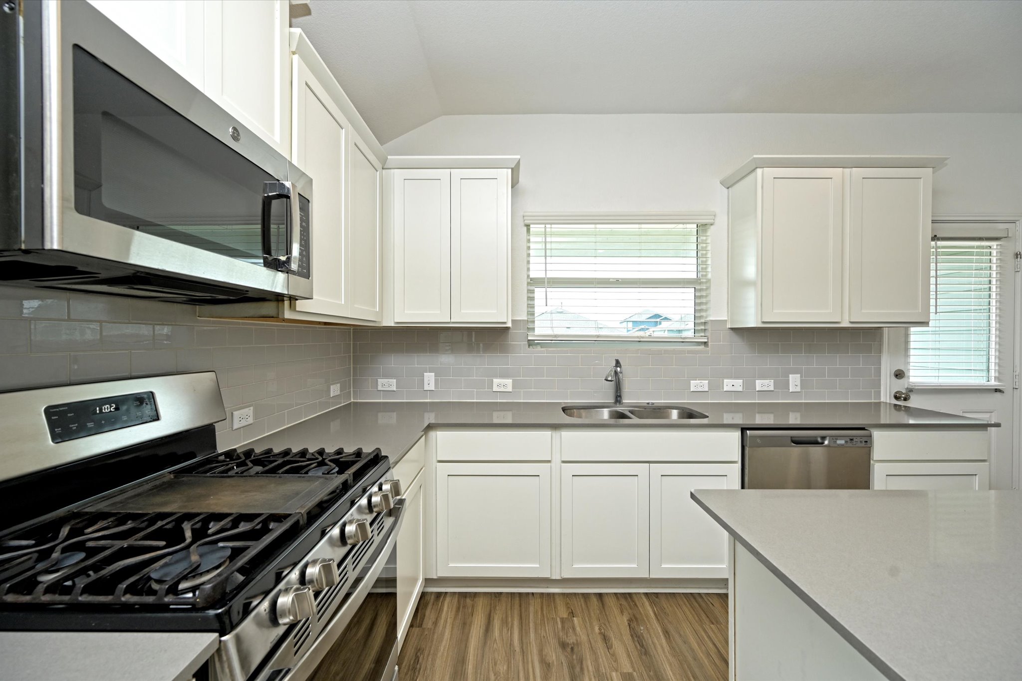 180 Madrid Kyle, TX 78640 - Photo 14 of 32 a kitchen with stainless steel appliances a sink a stove and microwave