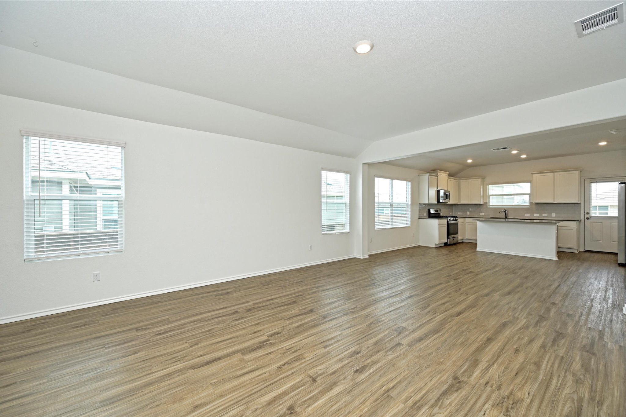 180 Madrid Kyle, TX 78640 - Photo 4 of 32 an empty room with wooden floor and windows