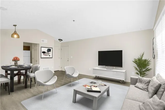 a living room with furniture a rug and a flat screen tv