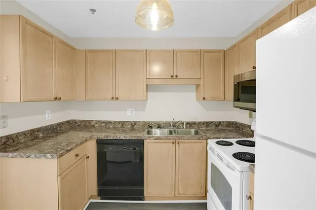 a kitchen with granite countertop white cabinets and white appliances