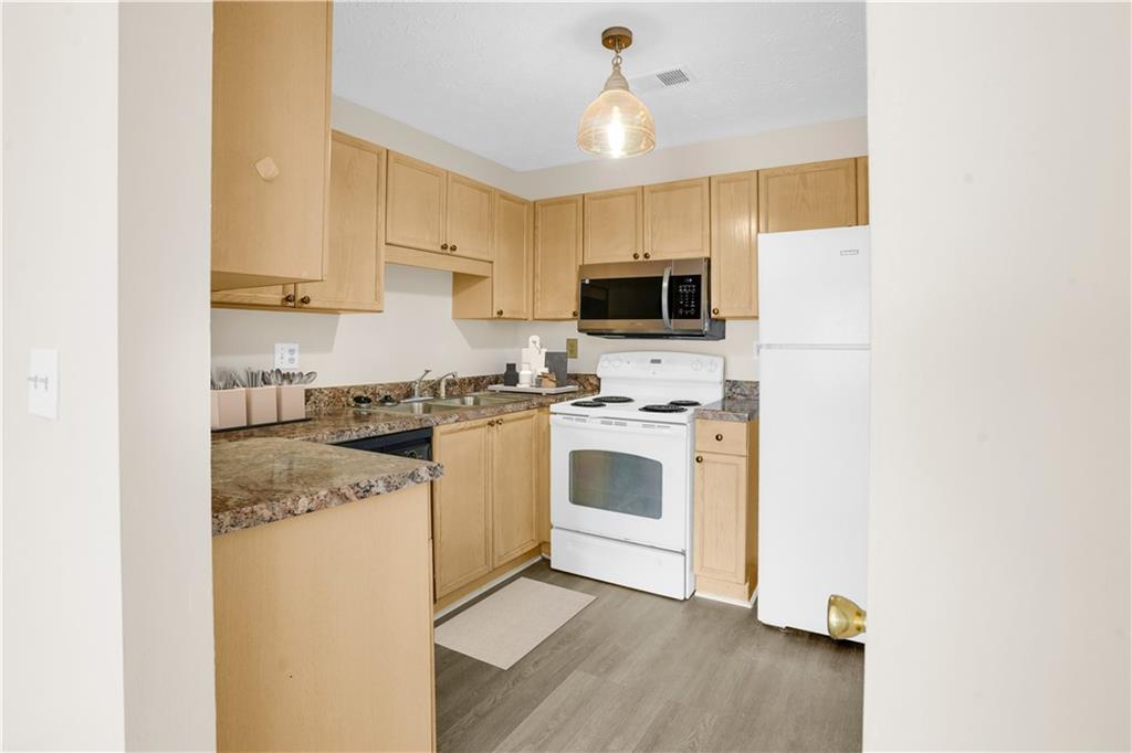 235 Bentley Place Tucker, GA 30084 - Photo 3 of 22 a kitchen with cabinets stainless steel appliances and wooden floor