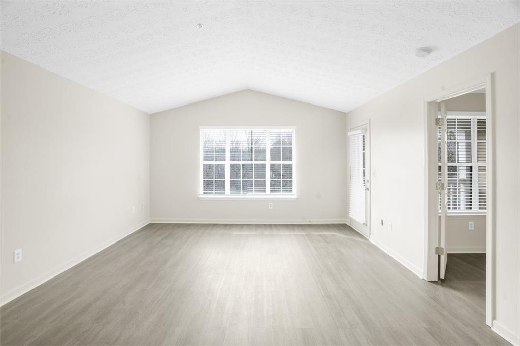 235 Bentley Place Tucker, GA 30084 - Photo 8 of 22 an empty room with wooden floor and windows
