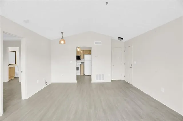 a view of an empty room with wooden floor