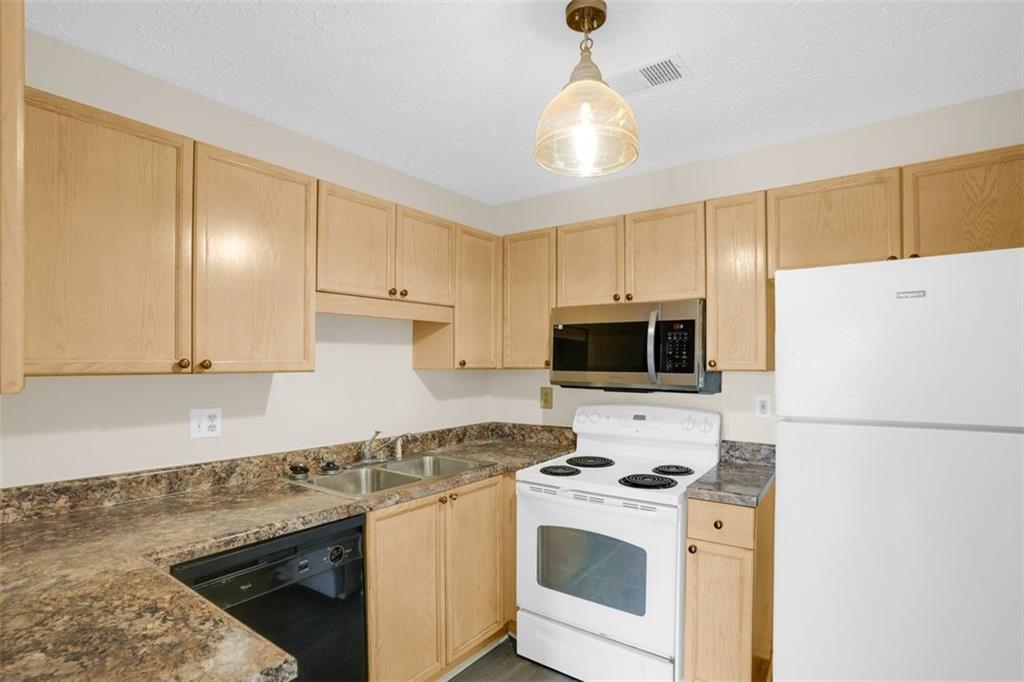 235 Bentley Place Tucker, GA 30084 - Photo 10 of 22 a kitchen with a stove a sink and a refrigerator