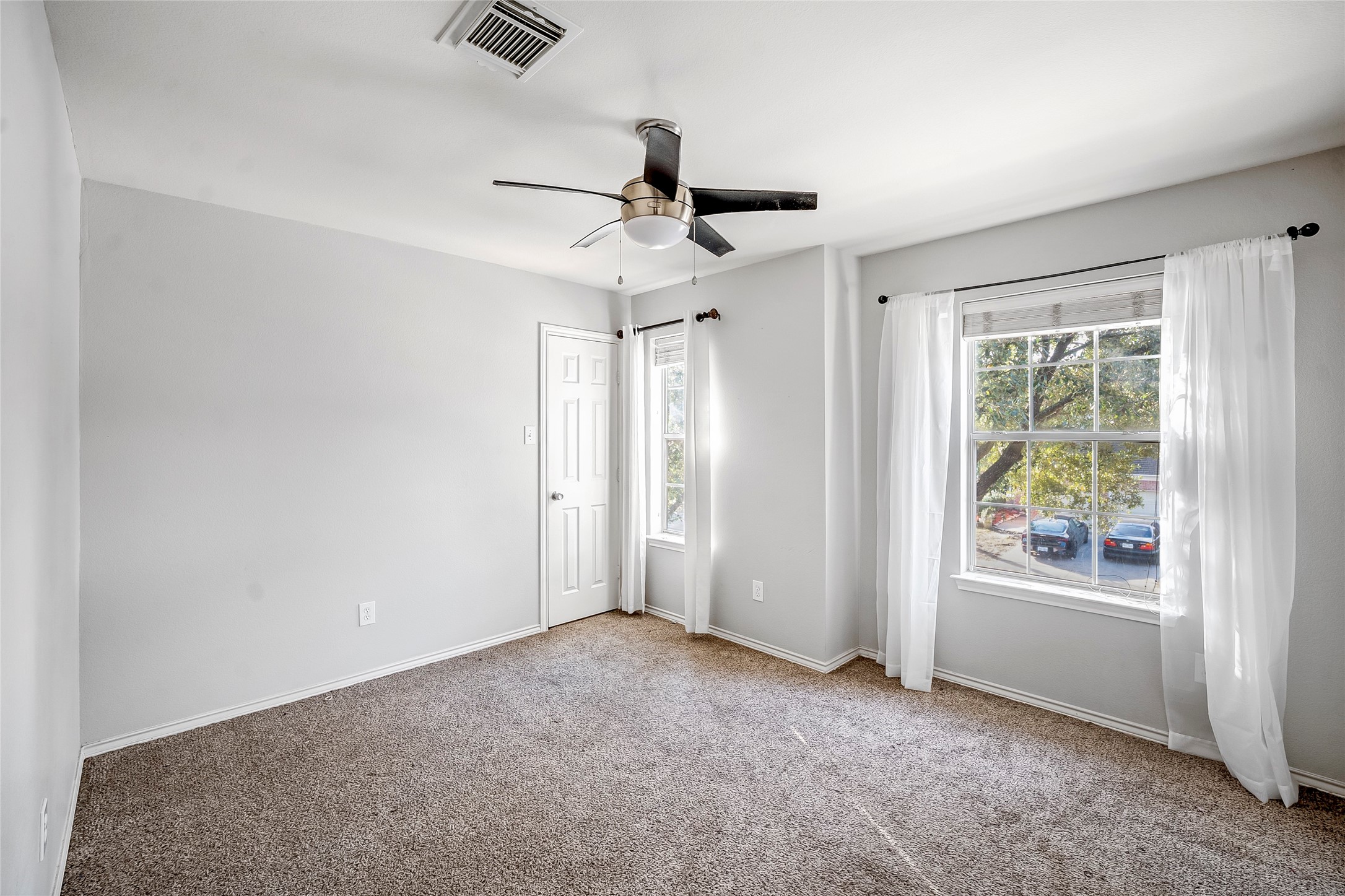 7403 Fall Springs Lane Humble, TX 77396 - Photo 12 of 16 an empty room with windows and ceiling fan
